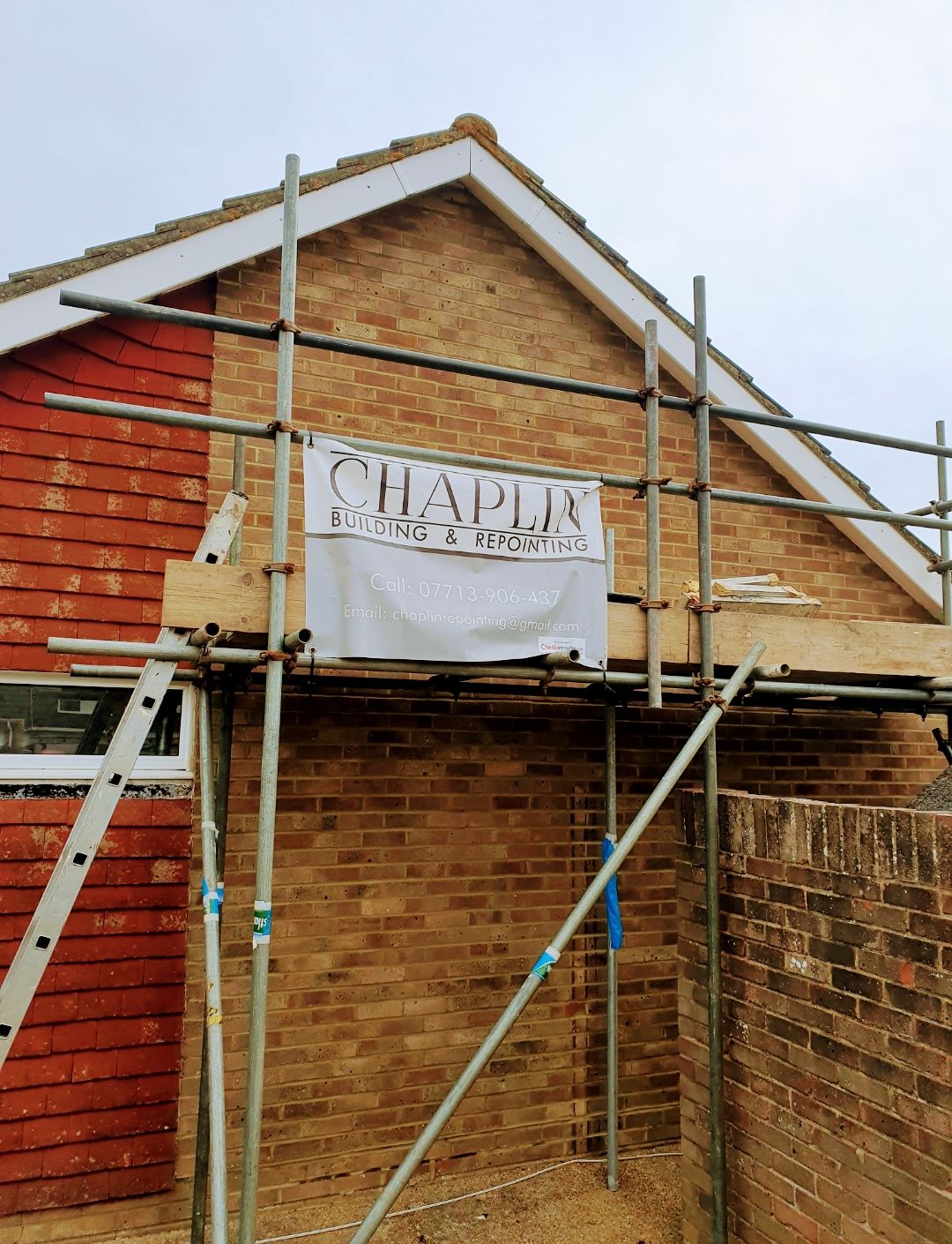 Gable end of a house on scaffold with a CHAPLIN banner