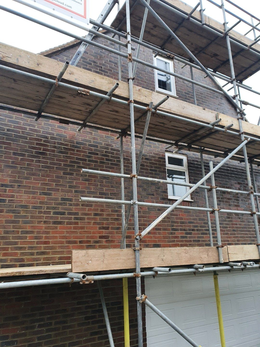 Scaffolding up against a brick house